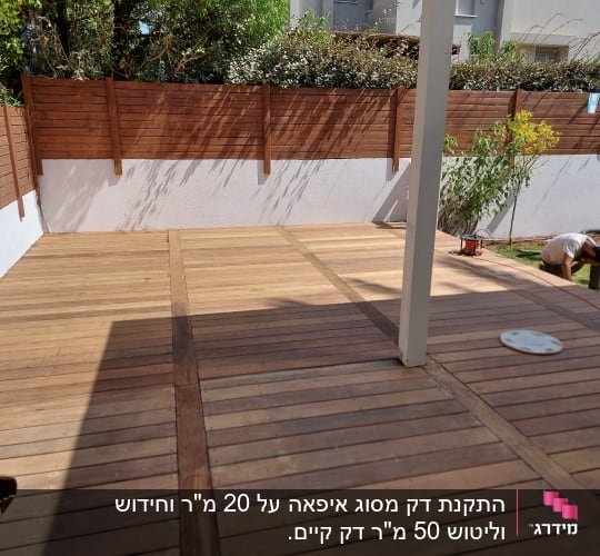 דק עץ בגינה עם גדר עץ חומה